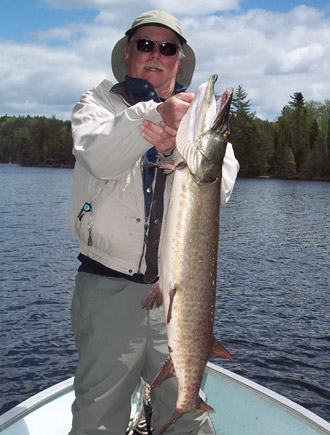 A guest holding a large muskie