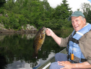 An angler on a rocky Michigan river with a big smallmouth bass