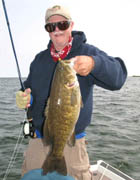 An angler on Lake Michigan with a big smallmouth bass