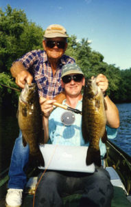 A father and son with a double catch of smallmouth bass