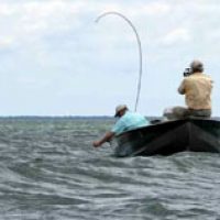 Two anglers in a boat on on a windy lake with rough waves