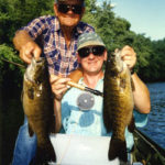 A father and son with a double catch of smallmouth bass