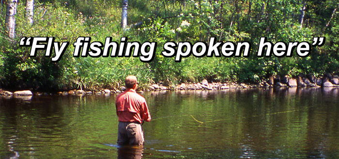 A fly fisher angler wading in a river